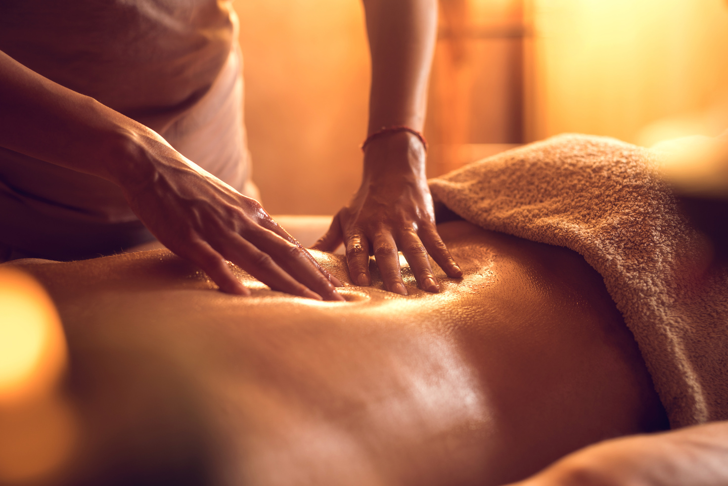 Unrecognizable massage therapist massaging man's back.